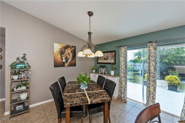 tiled dining room with lofted ceiling and an inviting chandelier