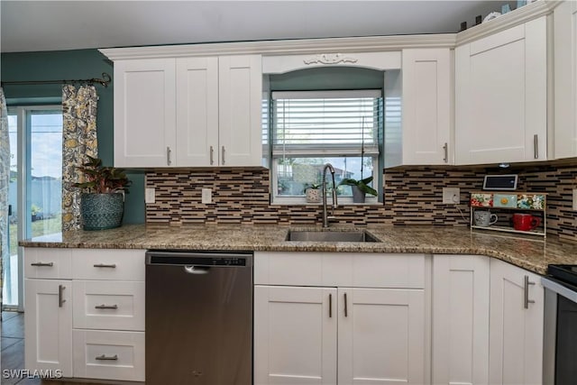 kitchen featuring backsplash, white cabinetry, stainless steel dishwasher, and sink