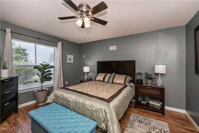 bedroom with multiple windows, hardwood / wood-style flooring, and ceiling fan