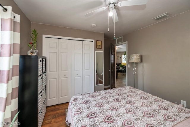 bedroom with dark hardwood / wood-style flooring, ceiling fan, and a closet