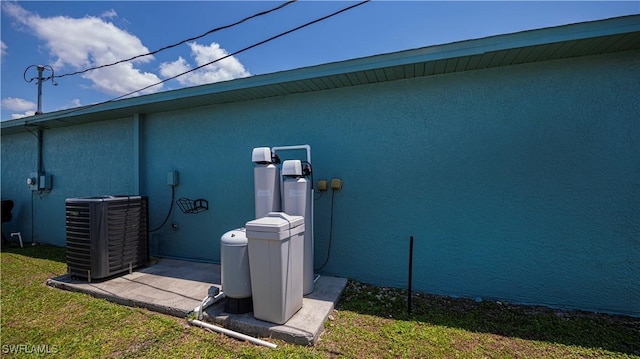 view of side of home featuring a yard and central AC