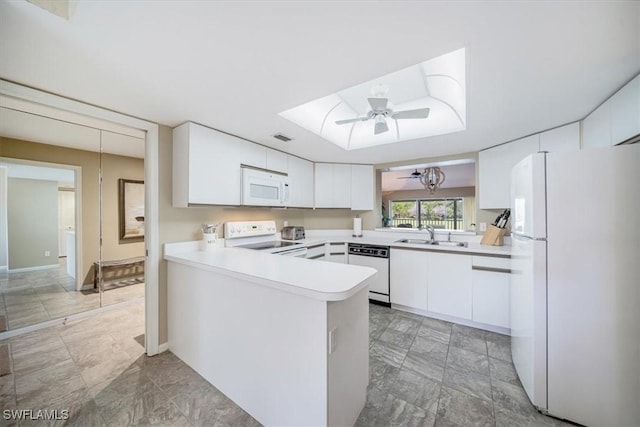 kitchen featuring white appliances, white cabinets, sink, ceiling fan, and kitchen peninsula