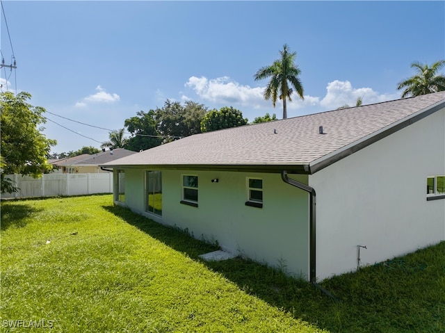 rear view of house featuring a yard