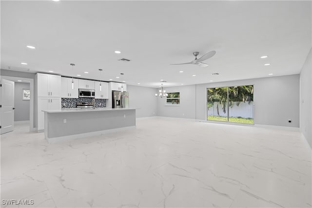 kitchen with stainless steel appliances, decorative backsplash, light tile patterned floors, a center island, and hanging light fixtures