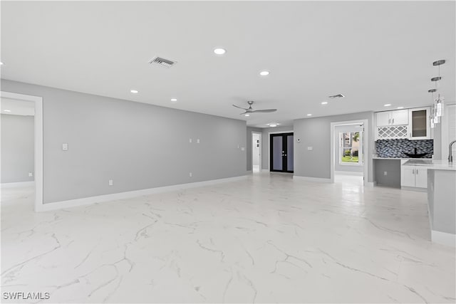 unfurnished living room featuring ceiling fan and light tile patterned flooring