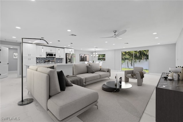 living room with ceiling fan with notable chandelier and light tile patterned floors