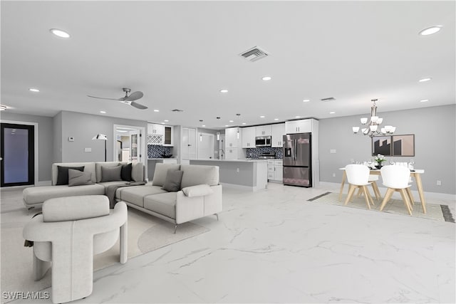 tiled living room with sink and ceiling fan with notable chandelier