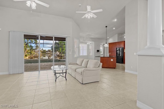 living area featuring a ceiling fan, high vaulted ceiling, baseboards, and light tile patterned floors