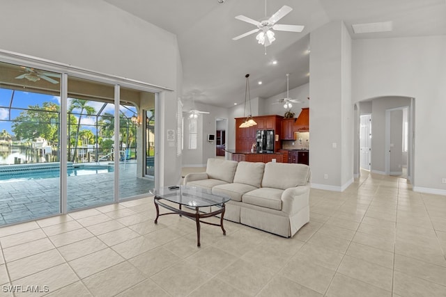 living room with high vaulted ceiling, light tile patterned flooring, and ceiling fan