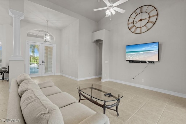 living area with baseboards, french doors, decorative columns, and tile patterned floors