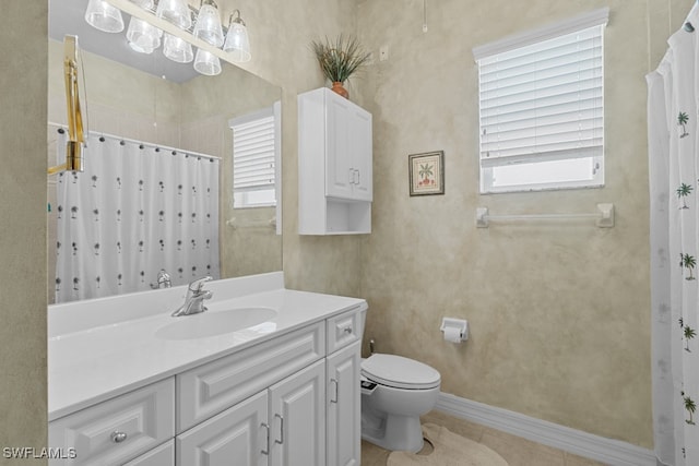 bathroom featuring tile patterned flooring, toilet, plenty of natural light, and vanity