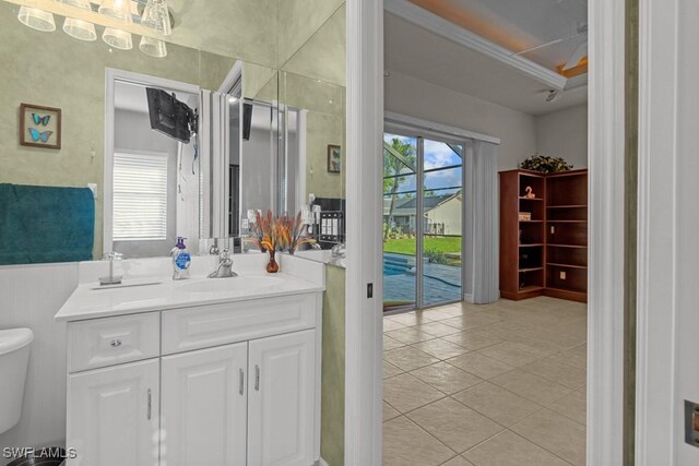 bathroom with crown molding, vanity, toilet, and tile patterned flooring