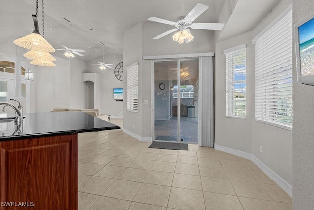 kitchen with light tile patterned floors, vaulted ceiling, arched walkways, and a sink