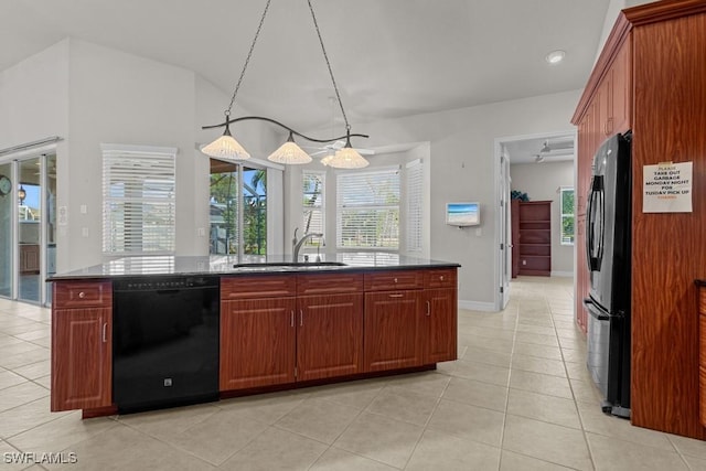 kitchen featuring light tile patterned flooring, a sink, black appliances, an island with sink, and pendant lighting