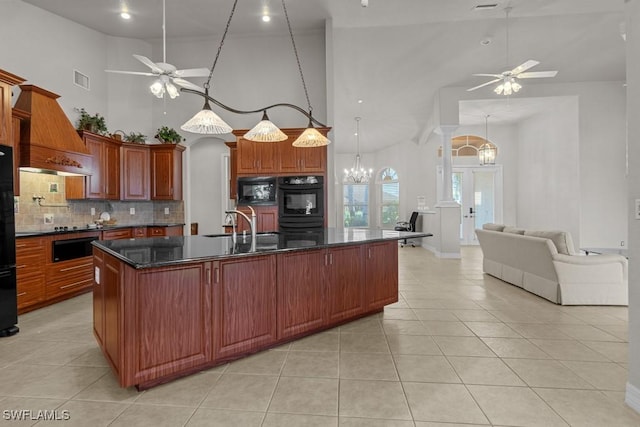 kitchen with decorative backsplash, open floor plan, black appliances, premium range hood, and ceiling fan with notable chandelier