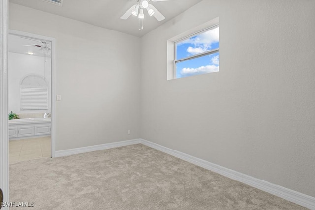 carpeted spare room with baseboards and a ceiling fan