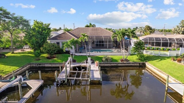 view of dock with a water view, a yard, and a lanai