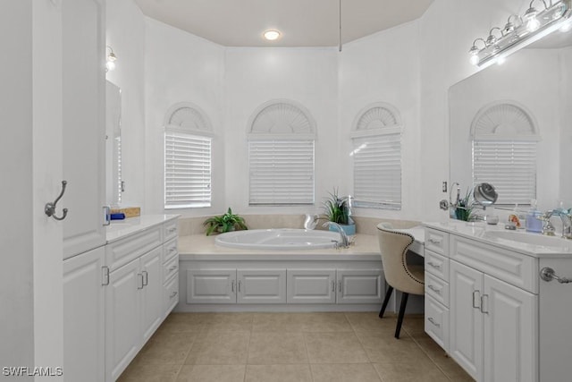 full bath with two vanities, a sink, a bath, and tile patterned floors