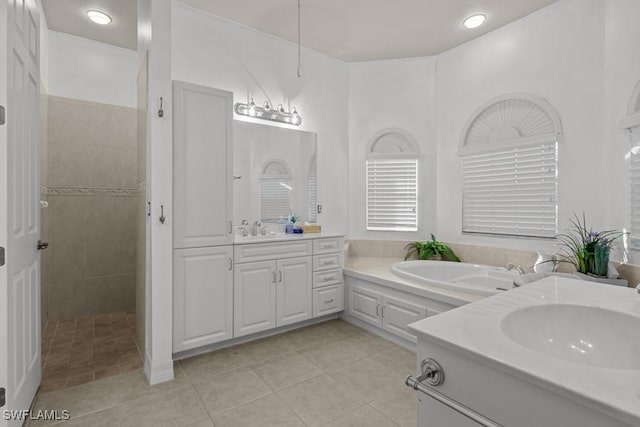 full bath with tile patterned flooring, two vanities, a sink, and walk in shower