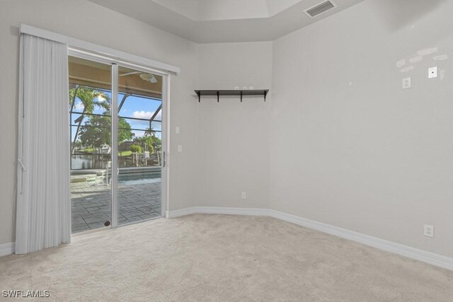 carpeted spare room featuring a sunroom, baseboards, and visible vents