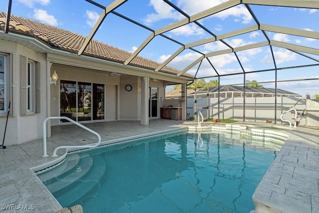 view of pool featuring a patio area, ceiling fan, glass enclosure, and a fenced in pool