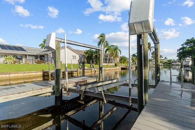 dock area featuring a water view, boat lift, and a residential view