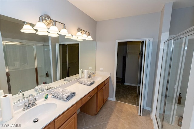 full bath with a stall shower, a sink, a spacious closet, and tile patterned floors