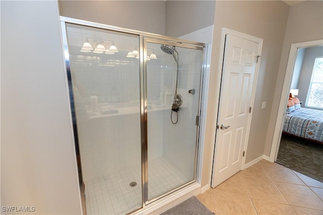 ensuite bathroom featuring ensuite bathroom, baseboards, a shower stall, and tile patterned floors