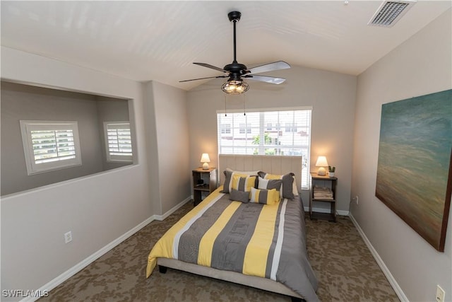 bedroom with vaulted ceiling, multiple windows, visible vents, and dark colored carpet