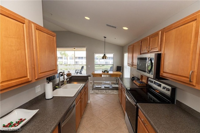 kitchen featuring light tile patterned floors, stainless steel appliances, dark countertops, visible vents, and a sink