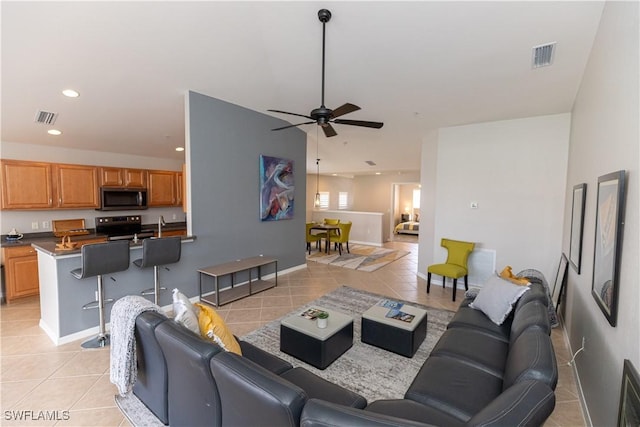 living area with light tile patterned floors, ceiling fan, visible vents, and recessed lighting