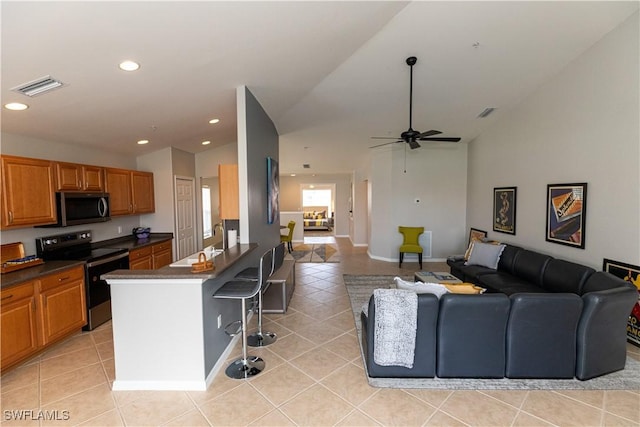 kitchen with appliances with stainless steel finishes, dark countertops, open floor plan, and visible vents