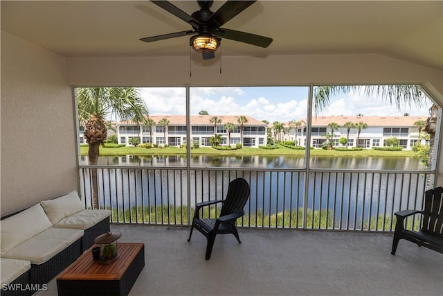 sunroom featuring vaulted ceiling, a water view, a residential view, and a ceiling fan