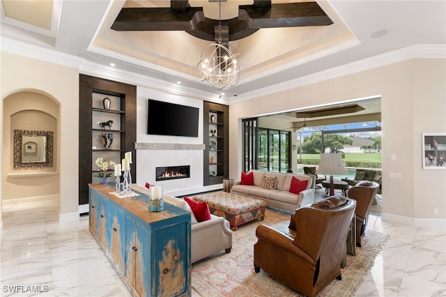 living room with a chandelier, a tray ceiling, built in features, and crown molding