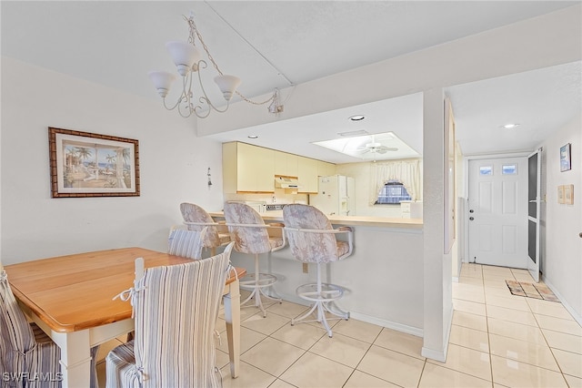 dining area featuring light tile patterned floors and ceiling fan with notable chandelier