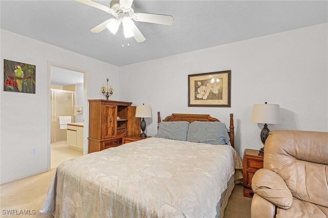 bedroom with light carpet, ensuite bath, and ceiling fan