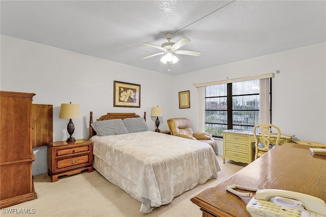 bedroom with ceiling fan, a textured ceiling, and light colored carpet