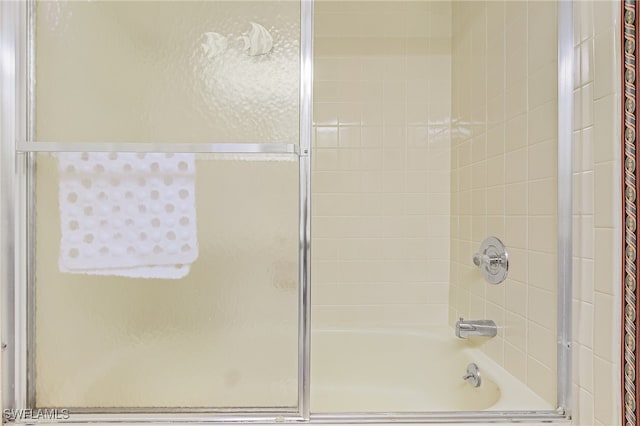 bathroom featuring combined bath / shower with glass door