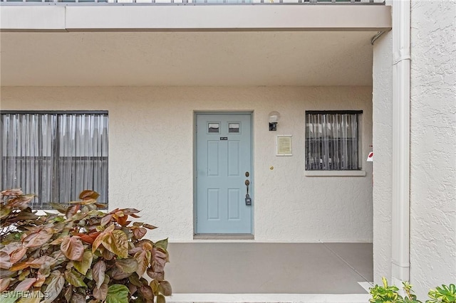 entrance to property with stucco siding