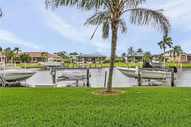 dock area featuring a yard, a water view, boat lift, and a residential view