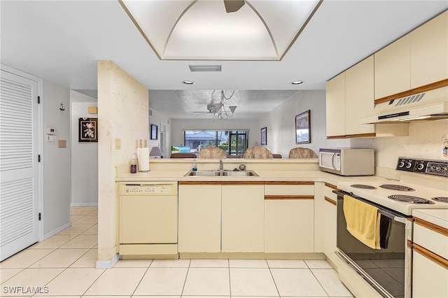 kitchen featuring white appliances, premium range hood, cream cabinets, sink, and kitchen peninsula