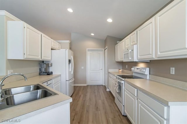 kitchen featuring white appliances, vaulted ceiling, light hardwood / wood-style floors, white cabinets, and sink