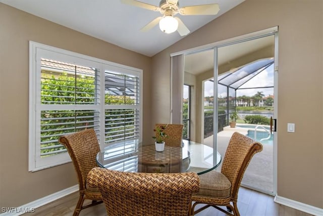 dining area featuring ceiling fan, vaulted ceiling, and hardwood / wood-style flooring