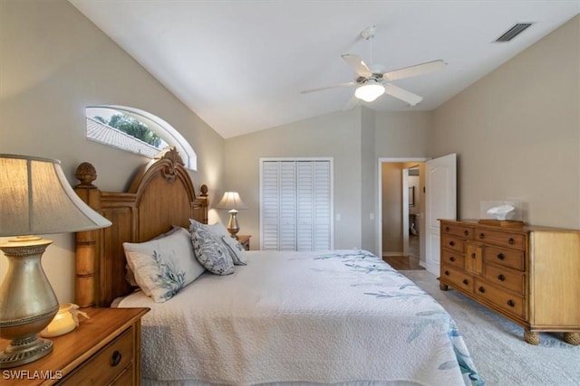 bedroom with a closet, ceiling fan, vaulted ceiling, and light colored carpet