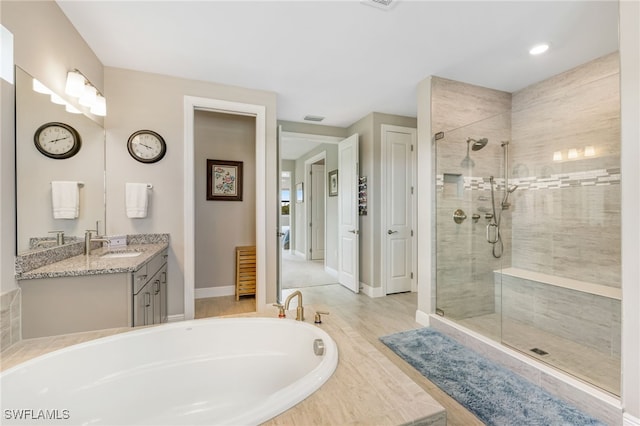 bathroom featuring hardwood / wood-style floors, vanity, and independent shower and bath