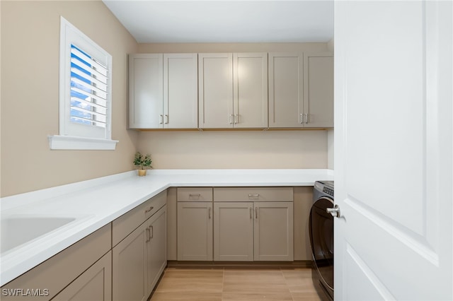 laundry area featuring sink, cabinets, and washer / dryer