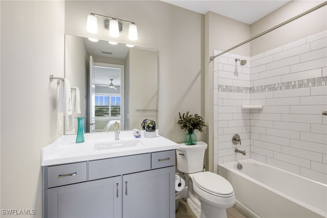 full bathroom featuring vanity, tiled shower / bath combo, and toilet