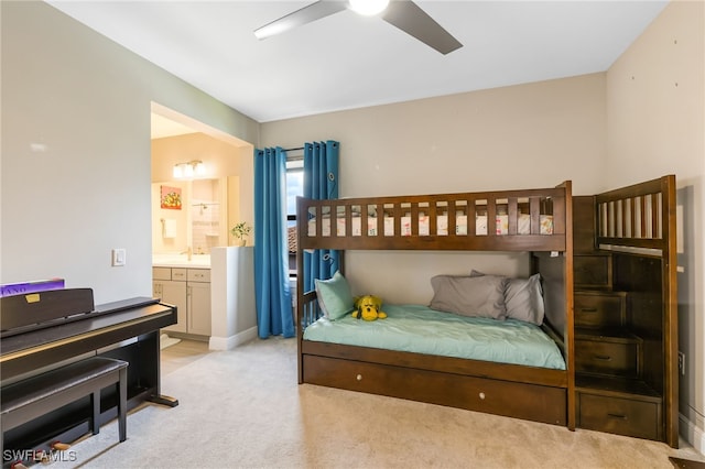 bedroom with ensuite bathroom, ceiling fan, and light colored carpet