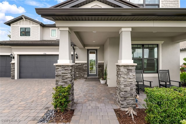 doorway to property with a porch and a garage