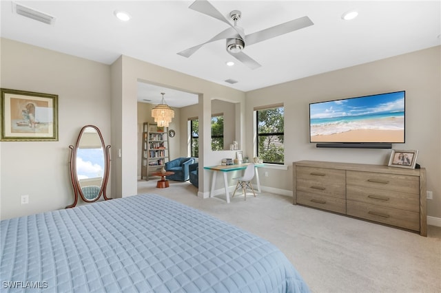 bedroom with ceiling fan with notable chandelier and light colored carpet